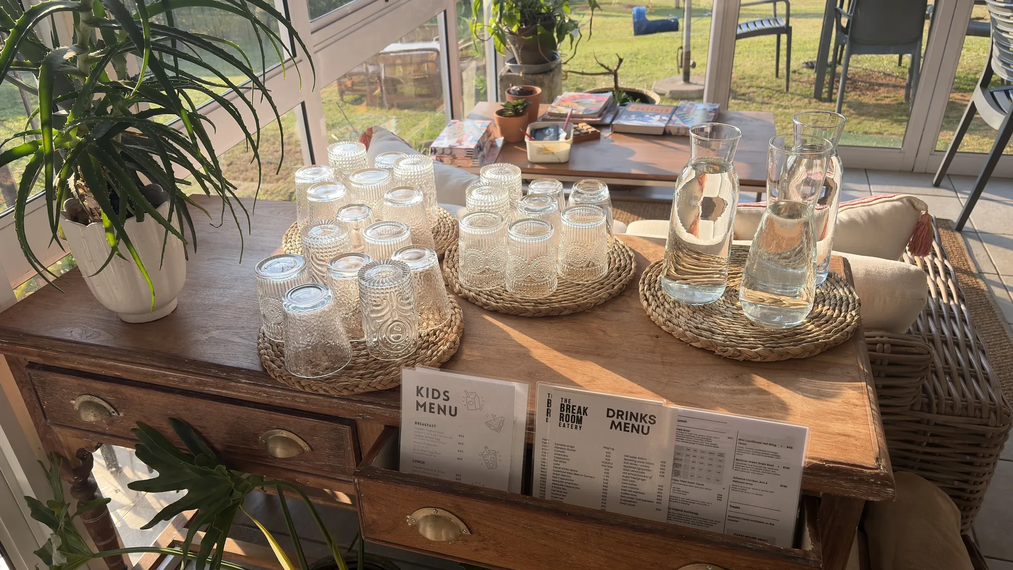 The decor corner with glassware, plants and menus on a wooden table