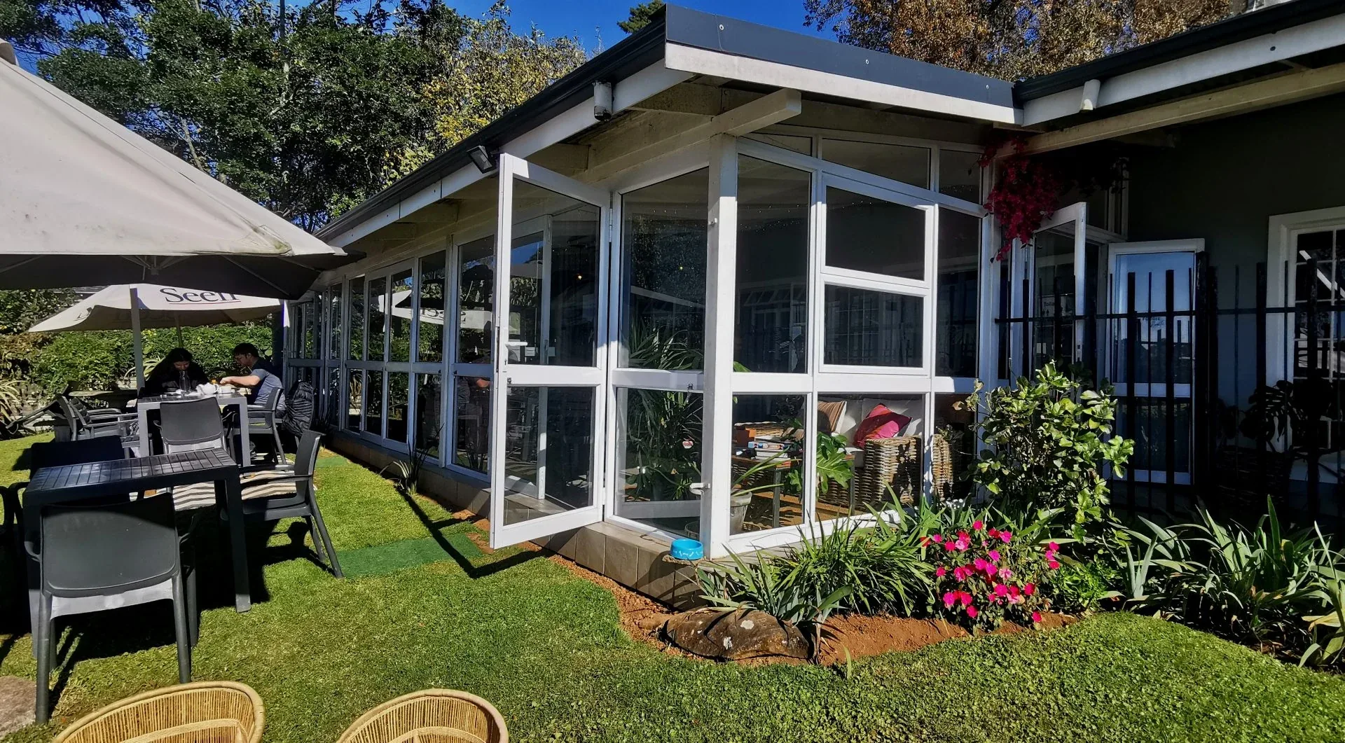 The garden and the glass sunroom at The Break Room on a sunny day